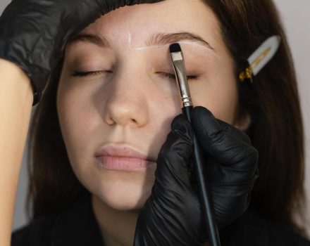 front-view-woman-getting-eyebrow-treatment-from-specialist